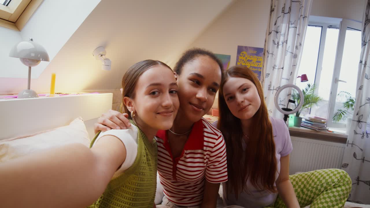 십대 소녀들이 침실에서 셀피를 찍고 있다