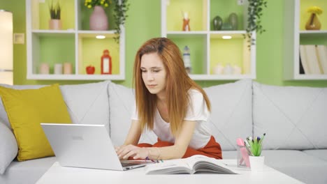 Happy-young-woman-texting-from-laptop.