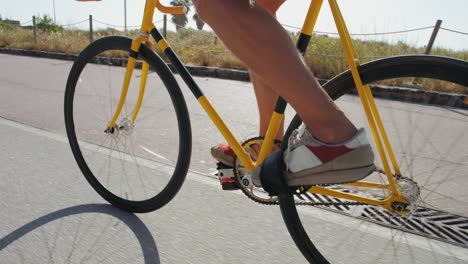 person riding a yellow track bike on a road