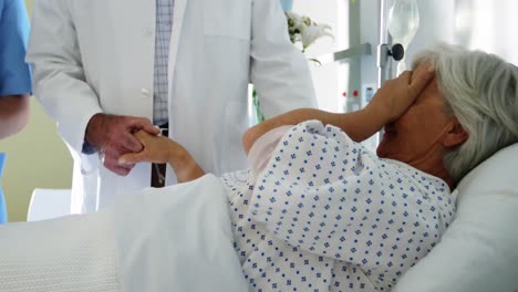 doctor trying to console crying female senior patient on the bed