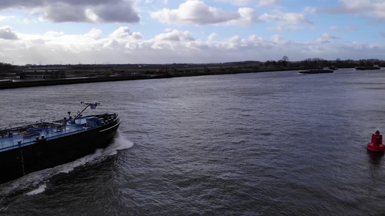 tanque de carga barco barcaza dejando estela en el río oude maas durante el día cerca de puttershoek, holanda del sur, países bajos