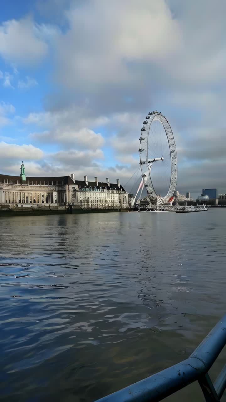 A large Ferris wheel is in the background of a body of water