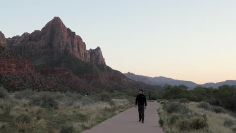 Hombre-Caminando-Por-El-Sendero-Del-Vigilante-En-El-Parque-Nacional-Zion,-Utah-Por-La-Noche