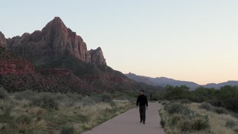 man walking the watchman trail in zion national park, utah in evening