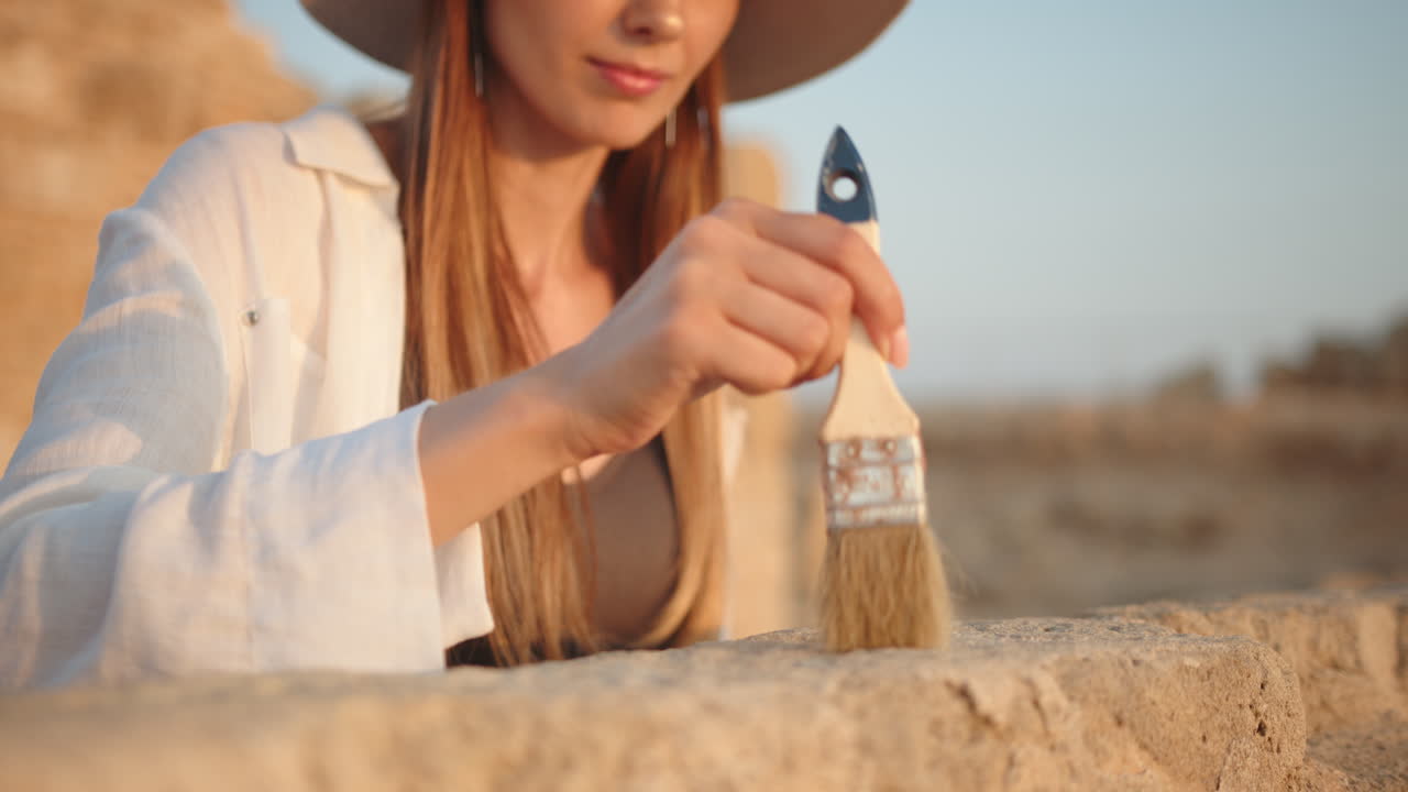 고대 유적 을 청소 하는 고고학자