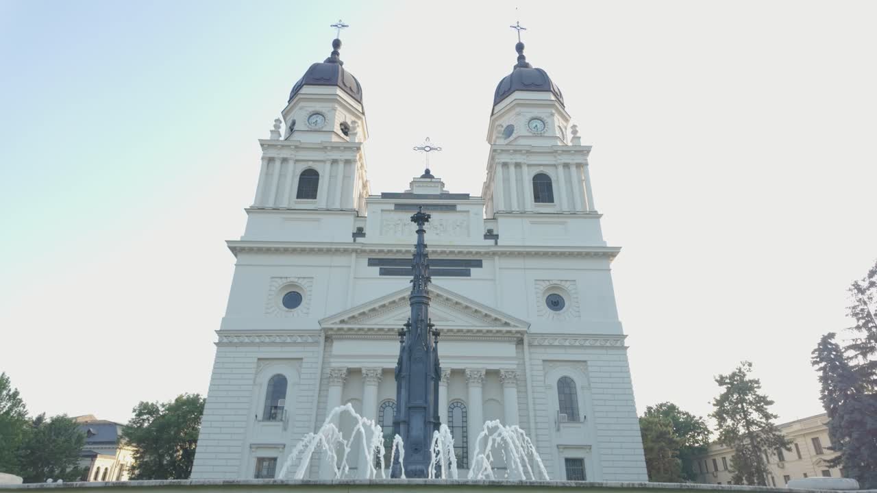 Historic Catedrala Trei Ierarhi in Iasi is framed by a fountain in the open city square