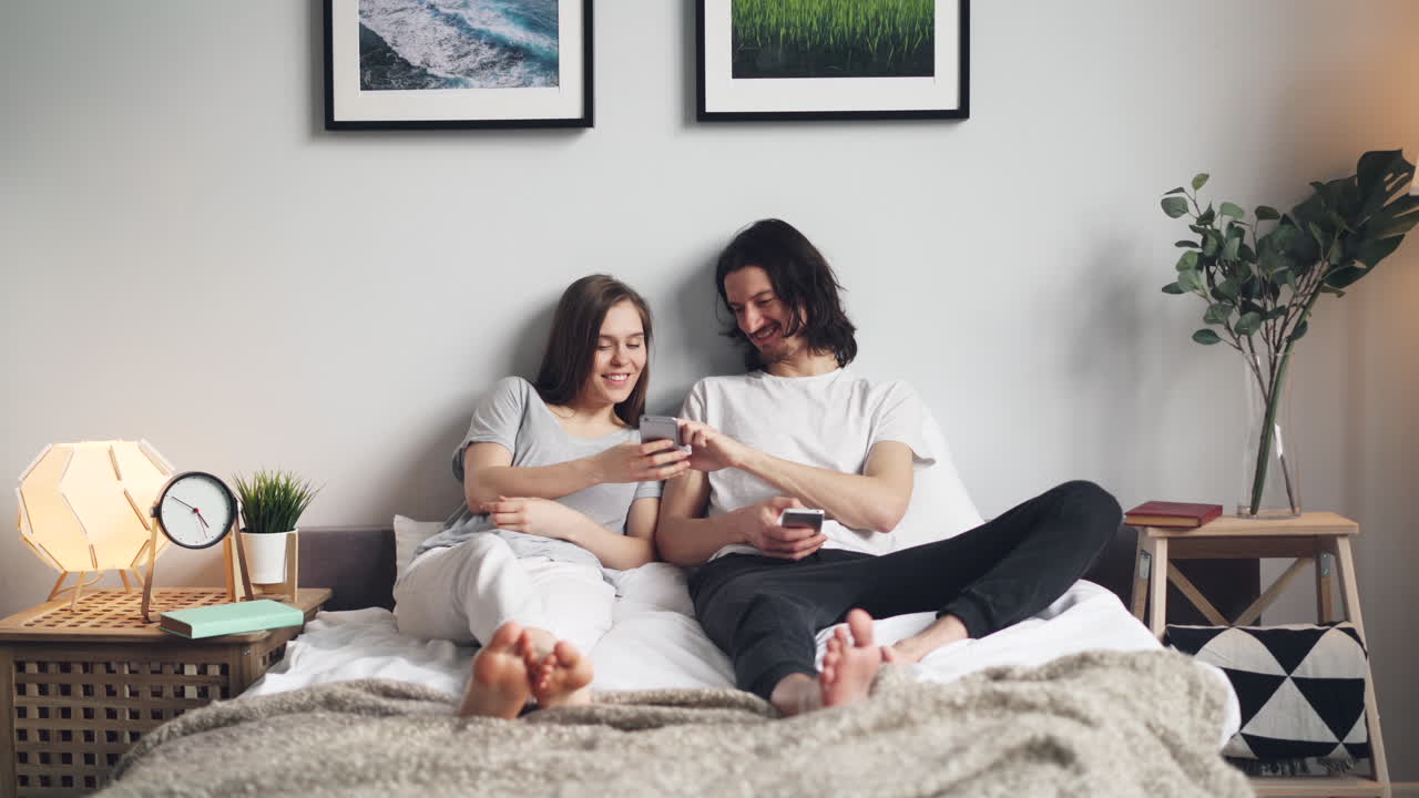 Couple Relaxing on Bed with Smartphones