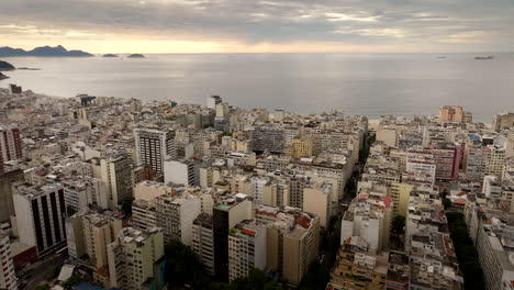 sunrise aerial flight over copacabana neighborhood rooftops toward beach, rio