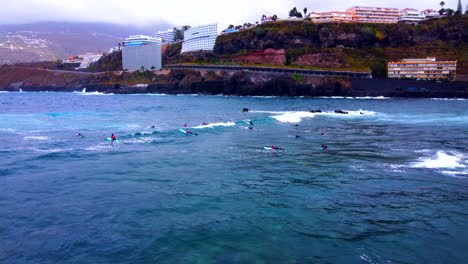 aerial shot of several surfers on their boards waiting for the waves