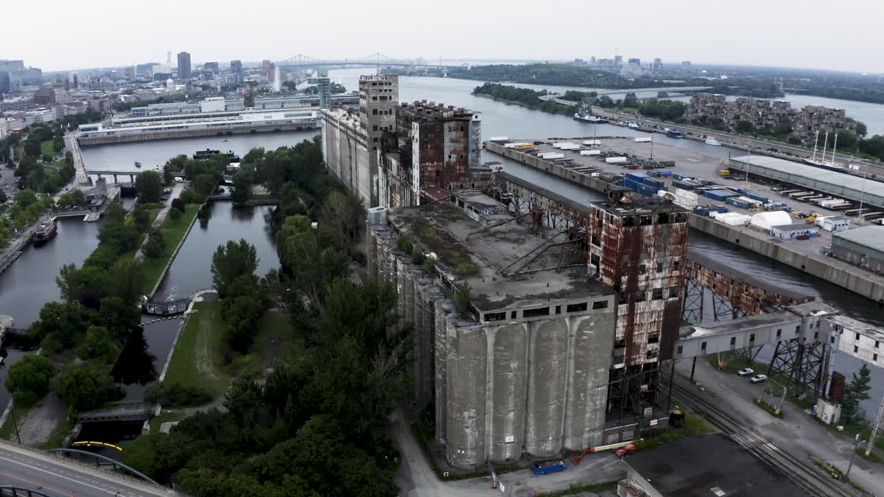 Aerial shot of an old shipping yard in Montreal, featuring rows of weathered containers and industrial cranes. Captures the raw, historical charm of the port's past operations.
