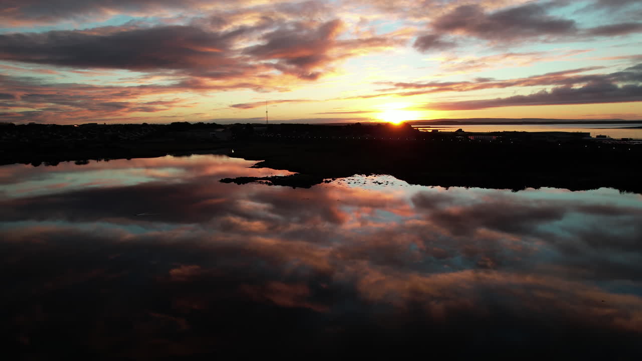 Aerial view of magical sunrise above bay and peninsula, mirror water reflection of scenic sky