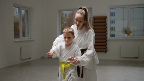 pupil and teacher in white kimono in martial arts class