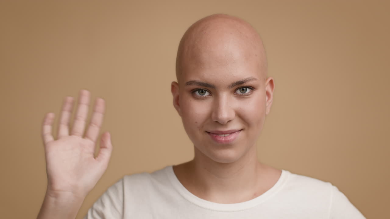 Woman with alopecia smiling and waving