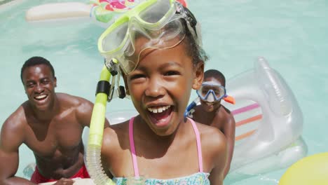 Happy-african-american-daughter-with-father-and-brother-relaxing-in-pool