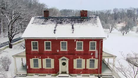 old red brick home covered in winter snow