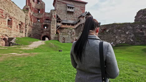 Young-female-inside-medieval-castle-Bauska-fortification-walls,-Latvia