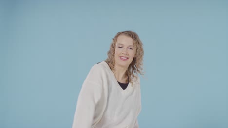 studio shot of young woman having fun dancing against blue background 5