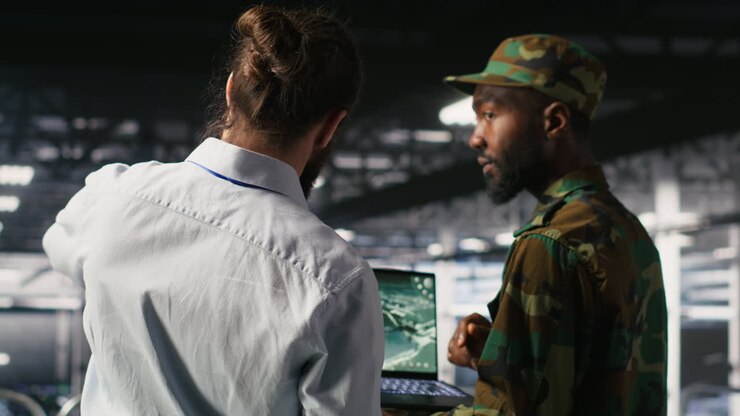 Military server hub technician reviewing tactical dashboard on laptop