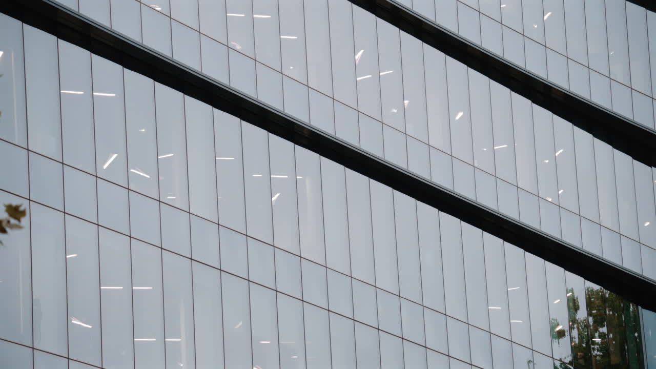 Architectural shot of a modern office building with reflective glass panels and geometric lines