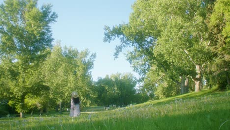 black woman on picnic in park running away and turning around low angle