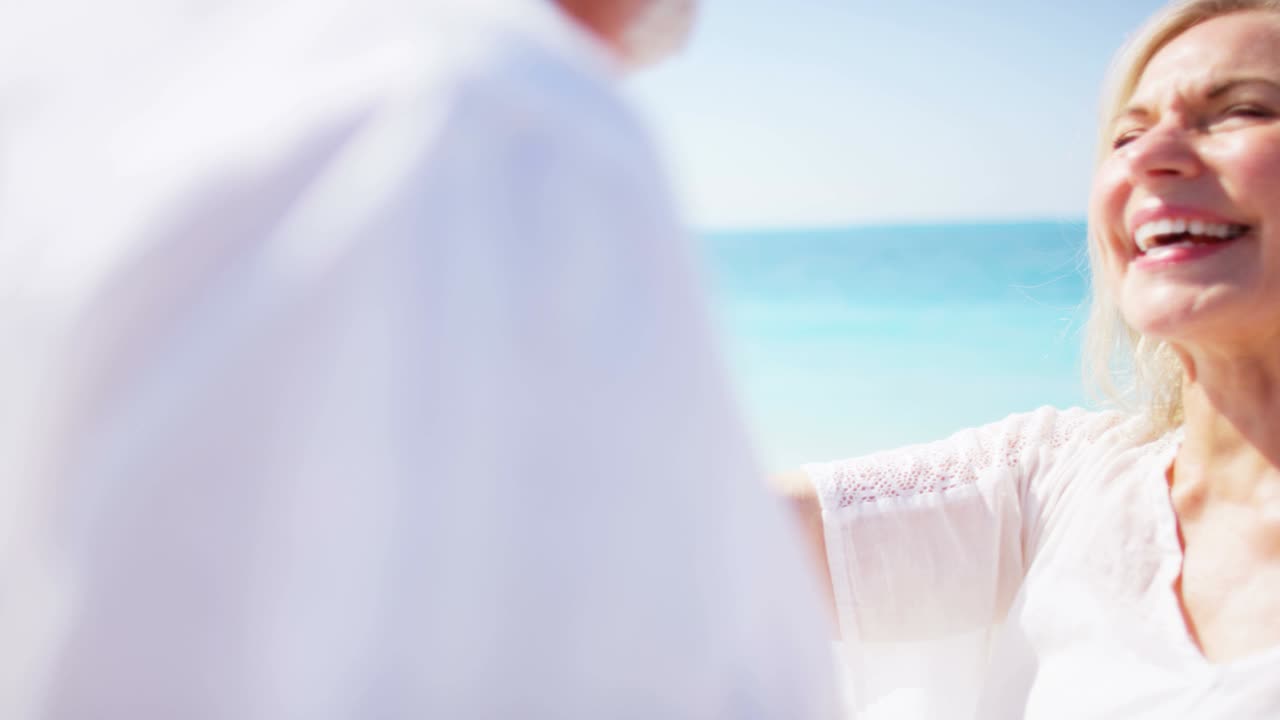 열대 해변에서 춤추는 성숙한 백인 커플