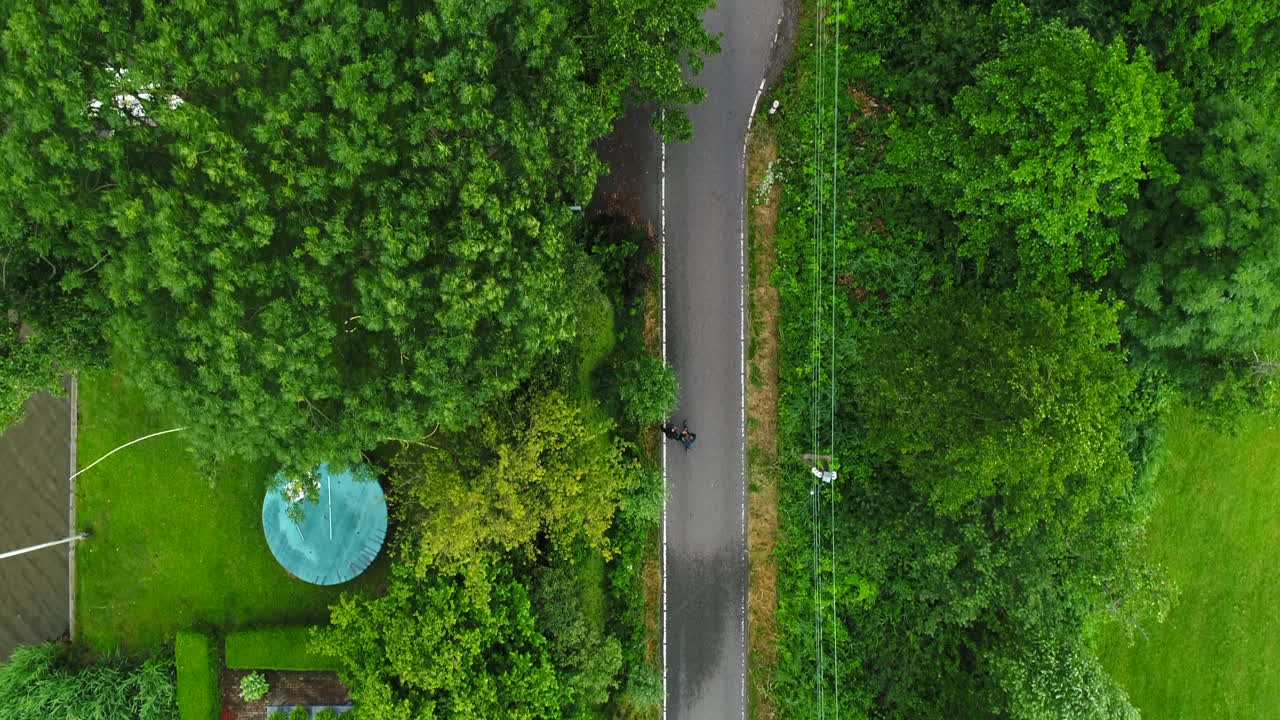 dos personas caminando juntas en una estrecha pasarela en un parque junto a un estanque rodeado de exuberantes árboles verdes y pastos en reeuwijkse plassen, países bajos
