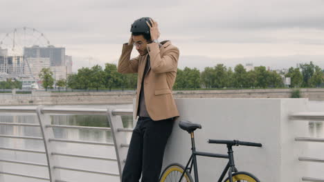 young american man in formal clothes wearing a bicycle helmet in the city