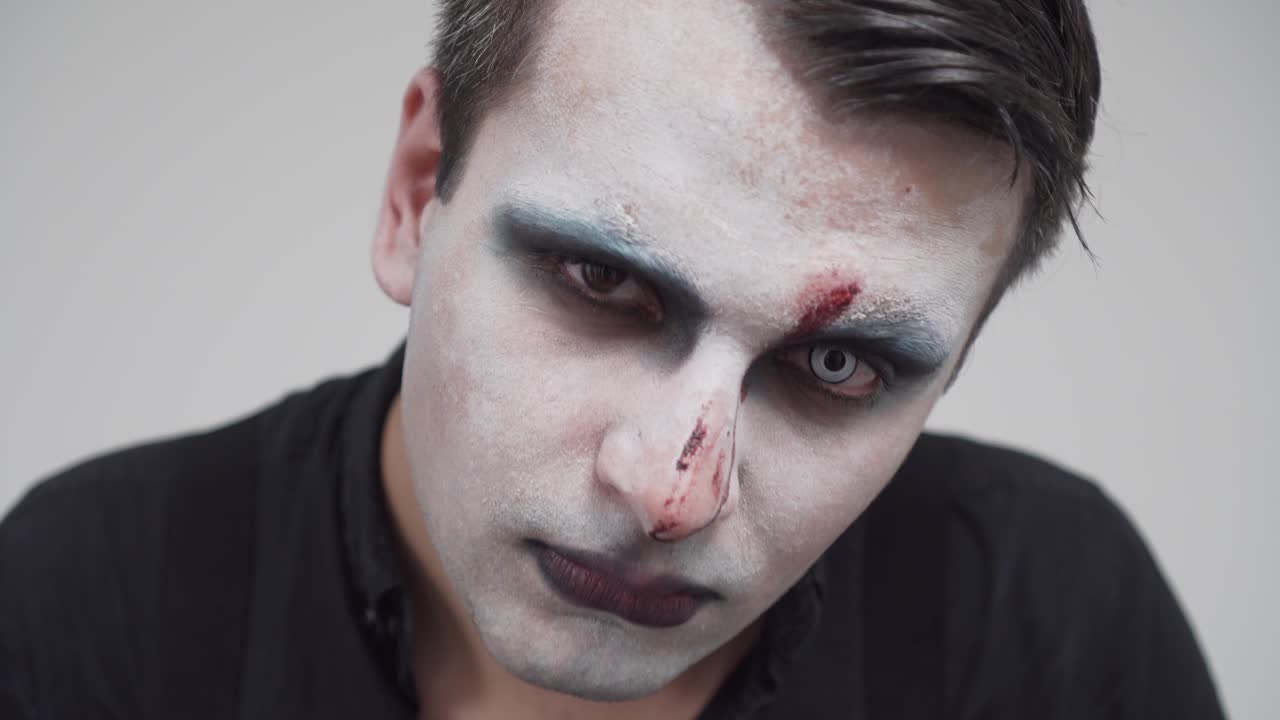 Closeup of man with face paint and scary contact lenses