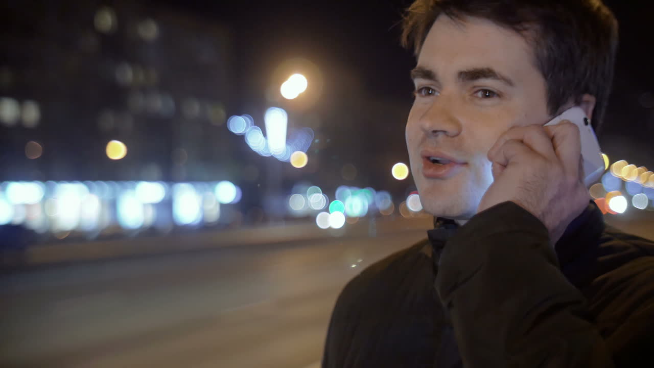 저녁 거리에서 전화로 이야기하는 남자