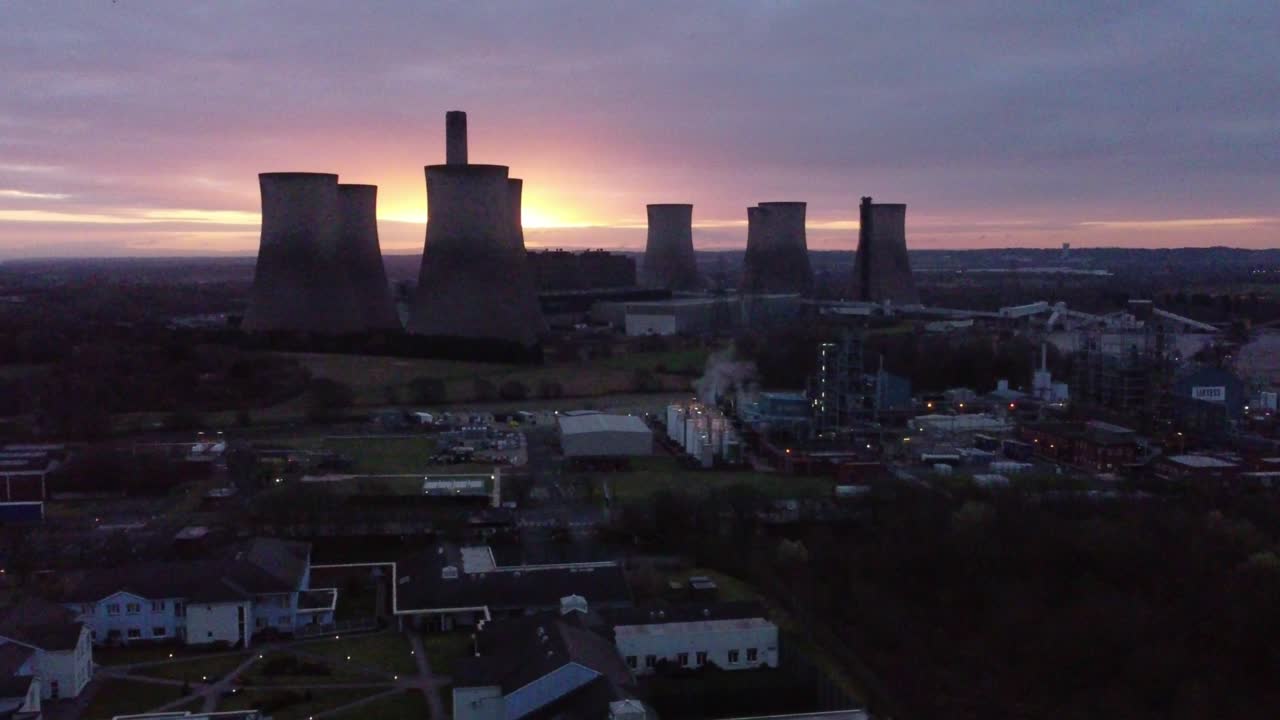 Fiddlers Ferry nedlagt kulfyret kraftværk ved solopgang under den gyldne time bag Warrington vartegn, luftfoto kredser til højre.