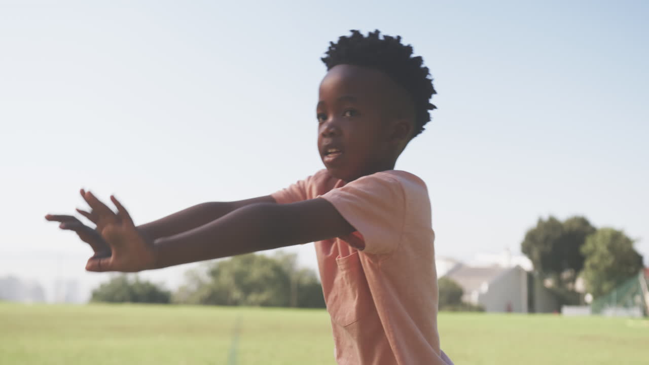 Playing outside, boy enjoying outdoor activity on school field during daytime