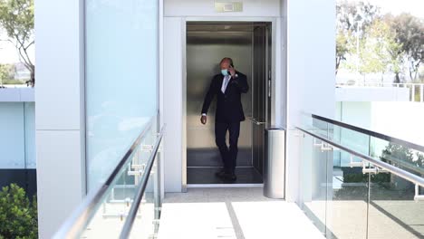 a model released mask wearing man kicks an elevator button during the covid19 coronavirus epidemic outbreak