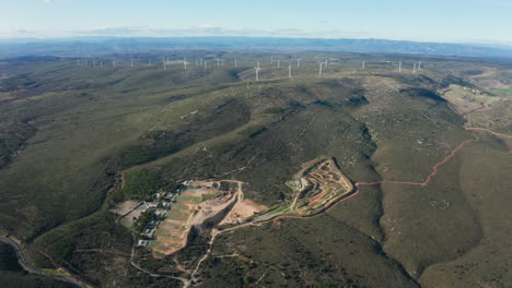 montañas con una cantera y turbinas eólicas granja francia aéreo día soleado