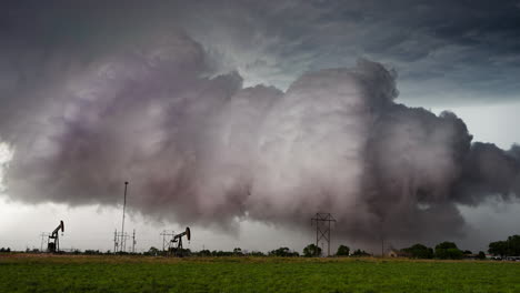 dramatic storm clouds loom over an oil field