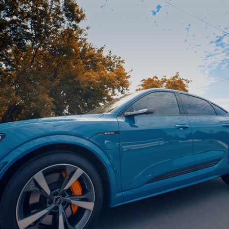 Presentation of a blue Audi e-tron, compact luxury crossover SUV. Modern new cars for sale