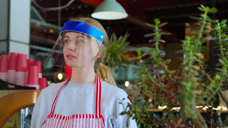 woman wearing protective face shield in a restaurant