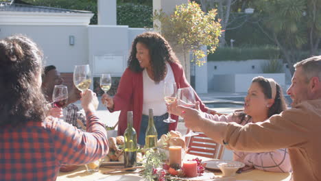 happy african american woman toasting on thanksgiving celebration meal in sunny garden