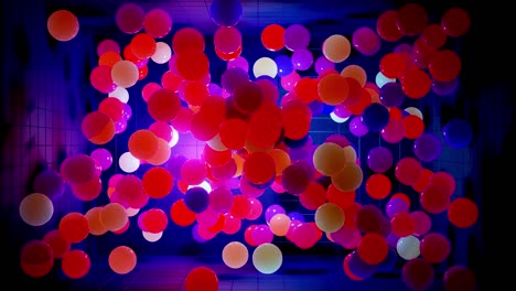 composición abstracta de bolas de colores en el aire, que se iluminan al azar y se reflejan entre sí. esferas multicolores en el aire como simple fondo oscuro geométrico con efectos de luz en la habitación oscura.