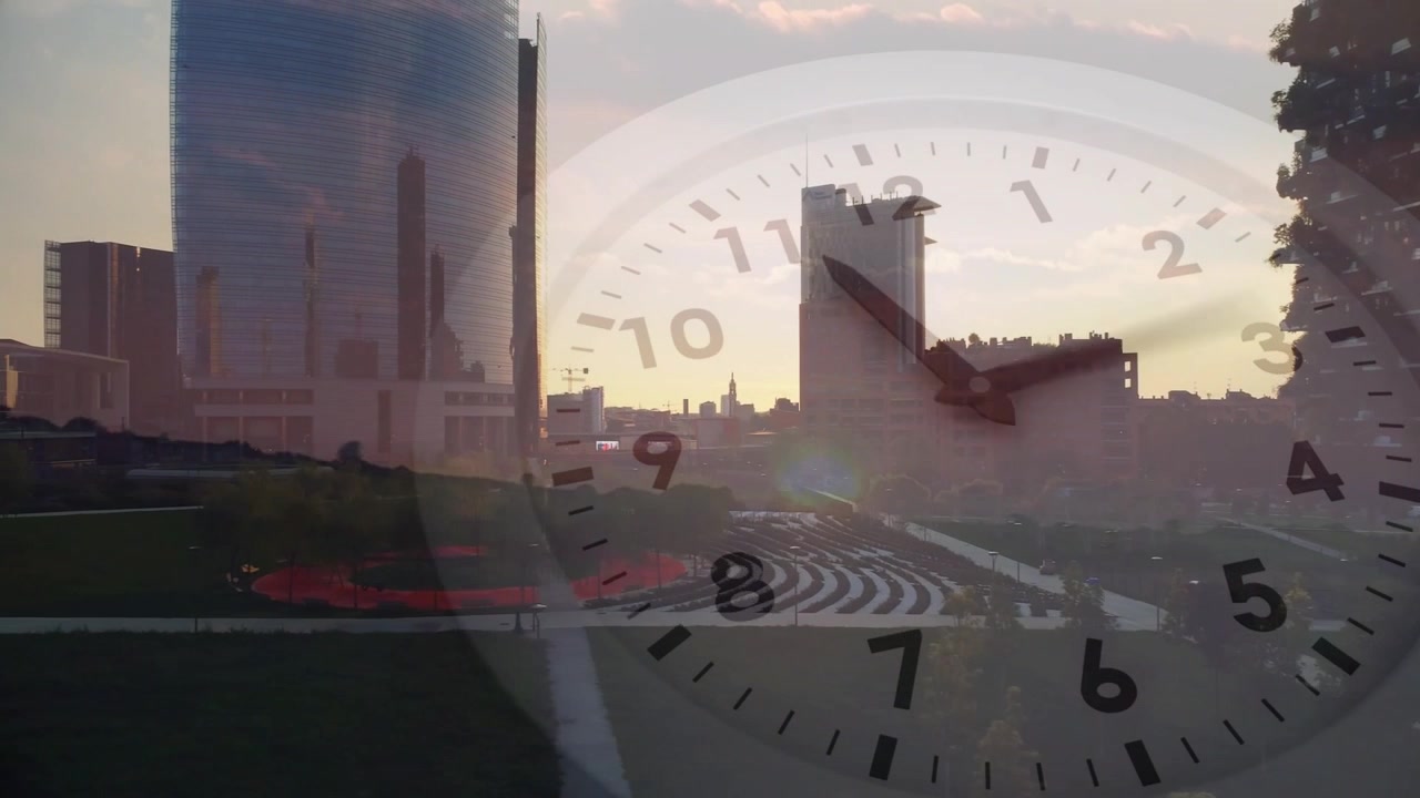 Sole che si sposta dietro un edificio di media altezza, facendo avanzare lancette traslucide dell'orologio attraverso lo skyline per mostrare l'ora.