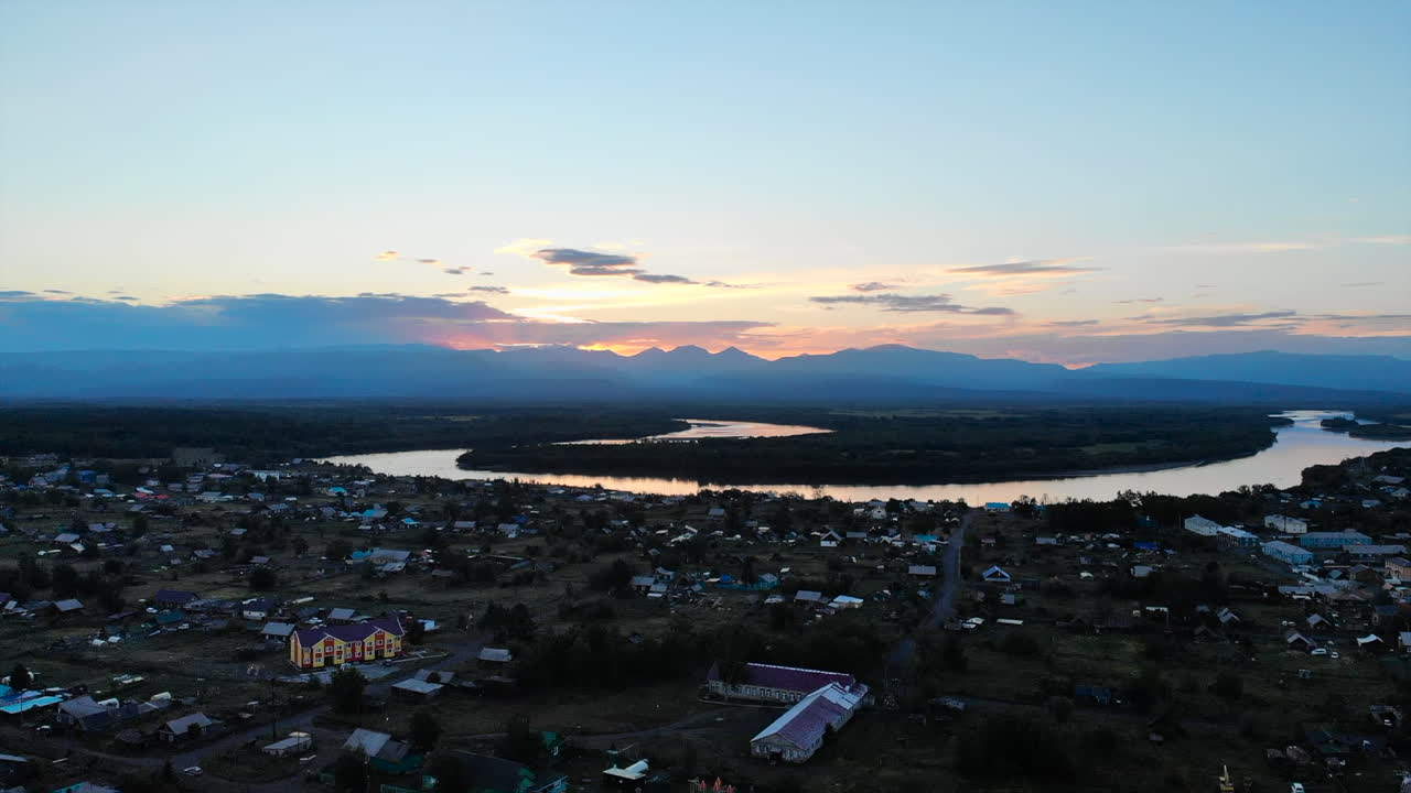 Aerial view of a village by a river at sunset