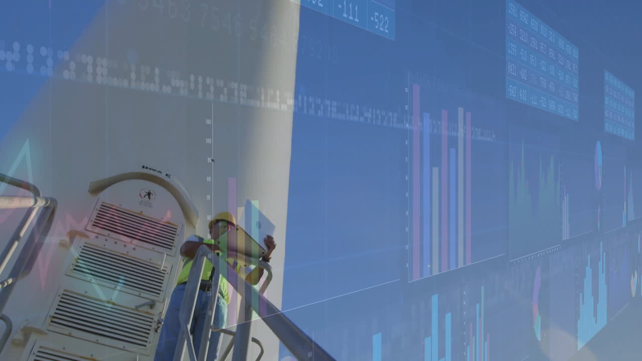 Man wearing hard hat holding laptop and analyzing data with animated charts on industrial catwalk