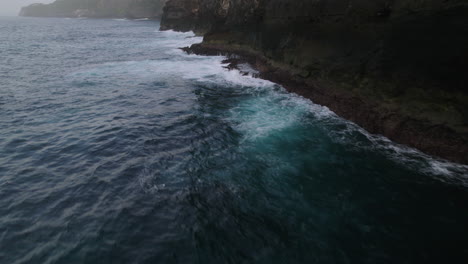 big waves crashing at the rocks at kelingking beach in bali