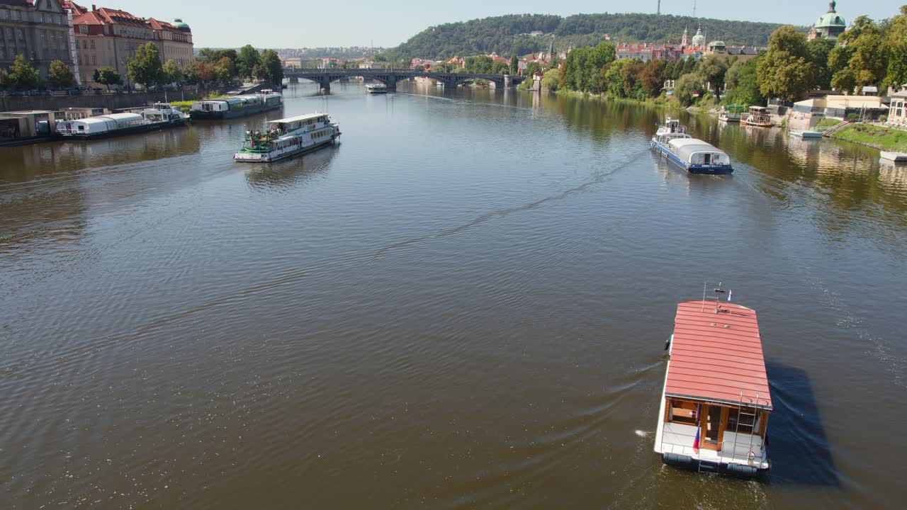 Battelli turistici lungo il fiume Moldava, Praga, in una giornata di sole con riprese aeree stabili