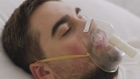 Sick-Man-Lying-On-Bed-Breathing-Through-Oxygen-Mask