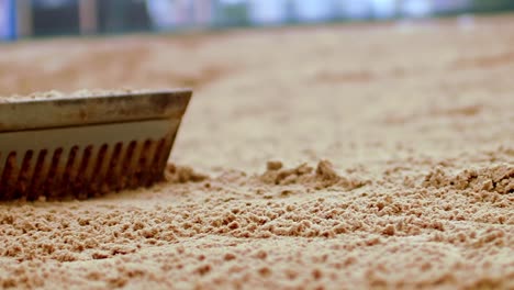 zoomed-in slow motion of raking sand on a beach tennis court