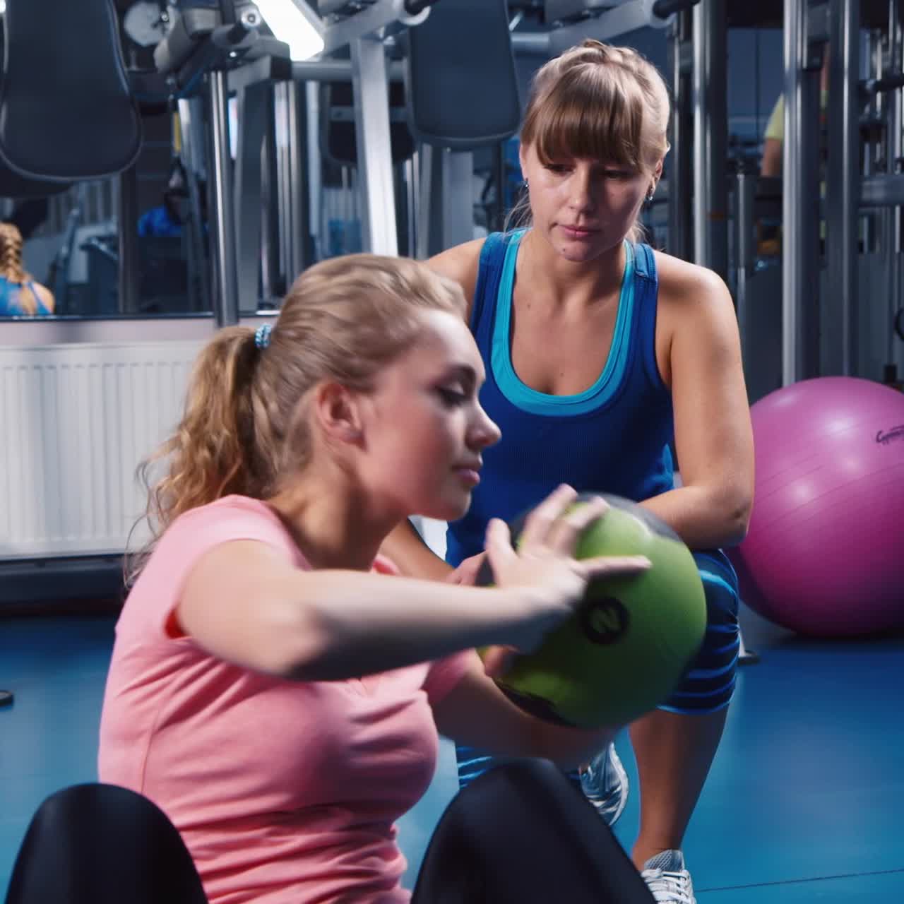 las mujeres jóvenes hacen entrenamiento físico en una pelota