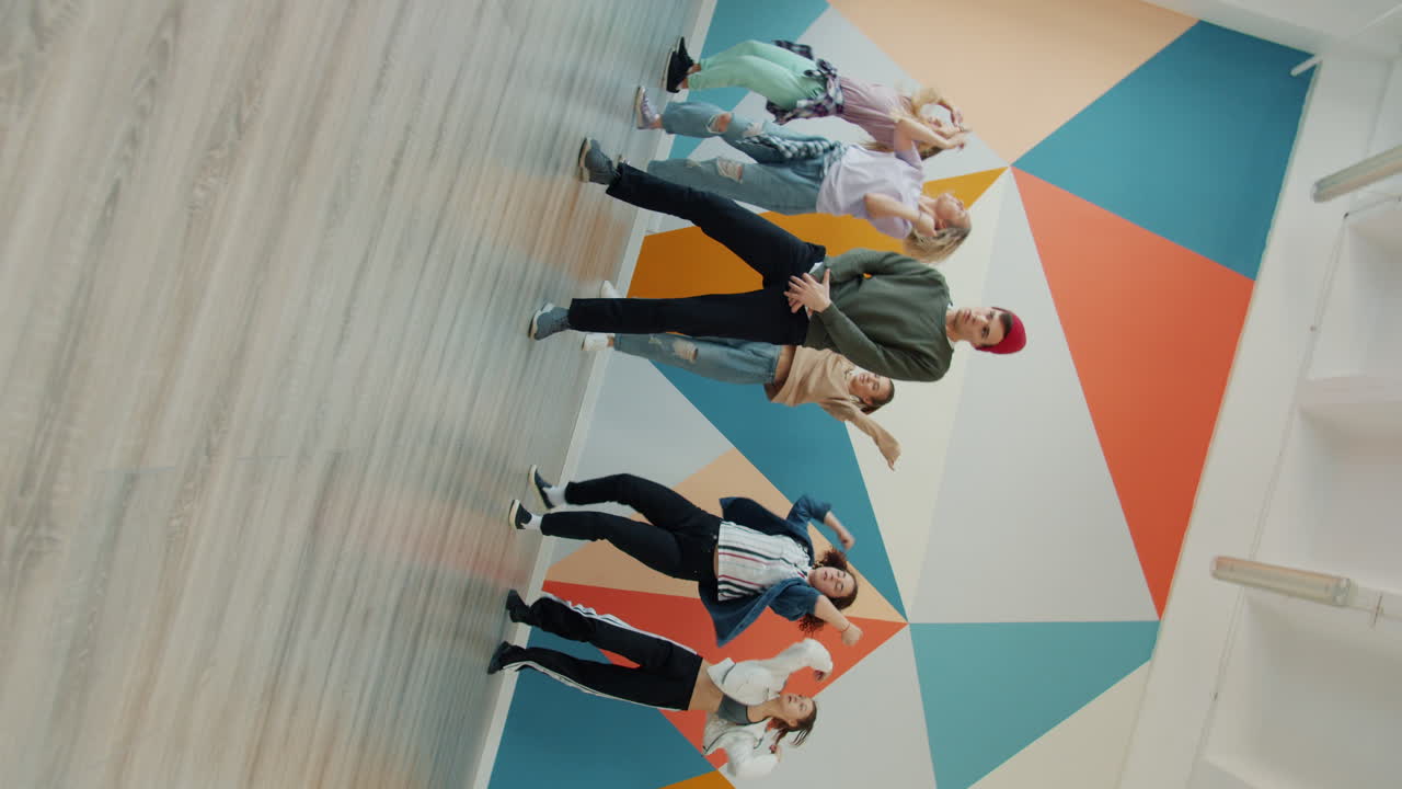 Group of young people dancing in a brightly colored studio