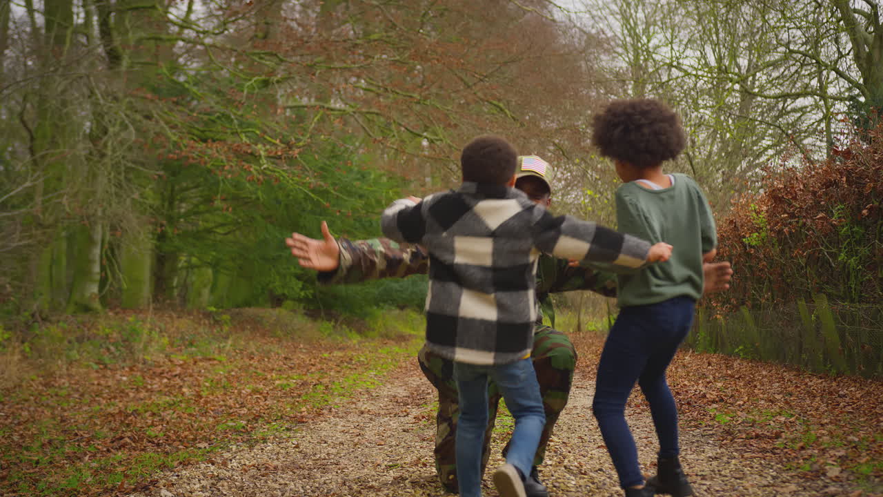 유니폼을 입은 미국 군인이 휴가를 마치고 집으로 돌아온 가족에게 두 아이가 환영합니다.