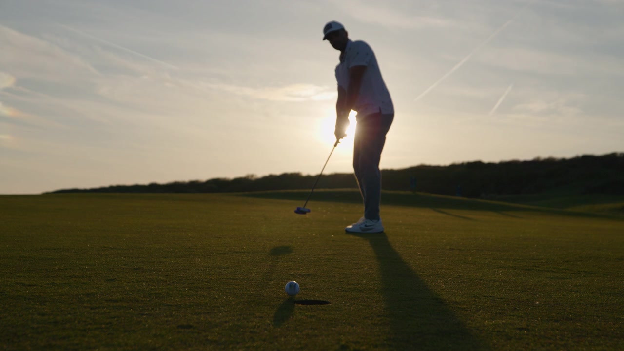 Sunset golf course putting shot misses hole, disappointment
