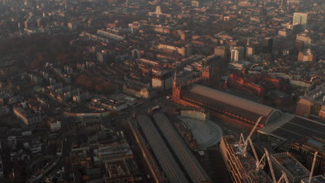 Descending-aerial-shot-over-Kings-cross-St-Pancras-train-stations-at-sunrise